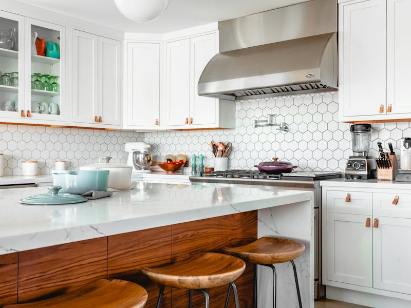 White custom kitchen with a range hood and wood island